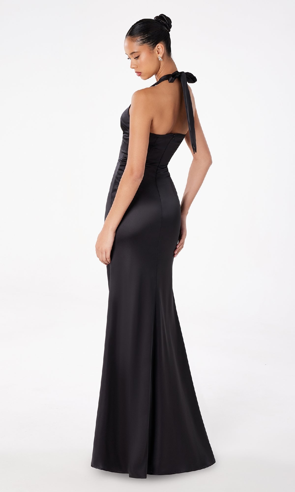A woman in the Bow-Back Long Satin Halter Prom Dress: Astee T2001 poses elegantly, looking down over her shoulder against a plain white background.